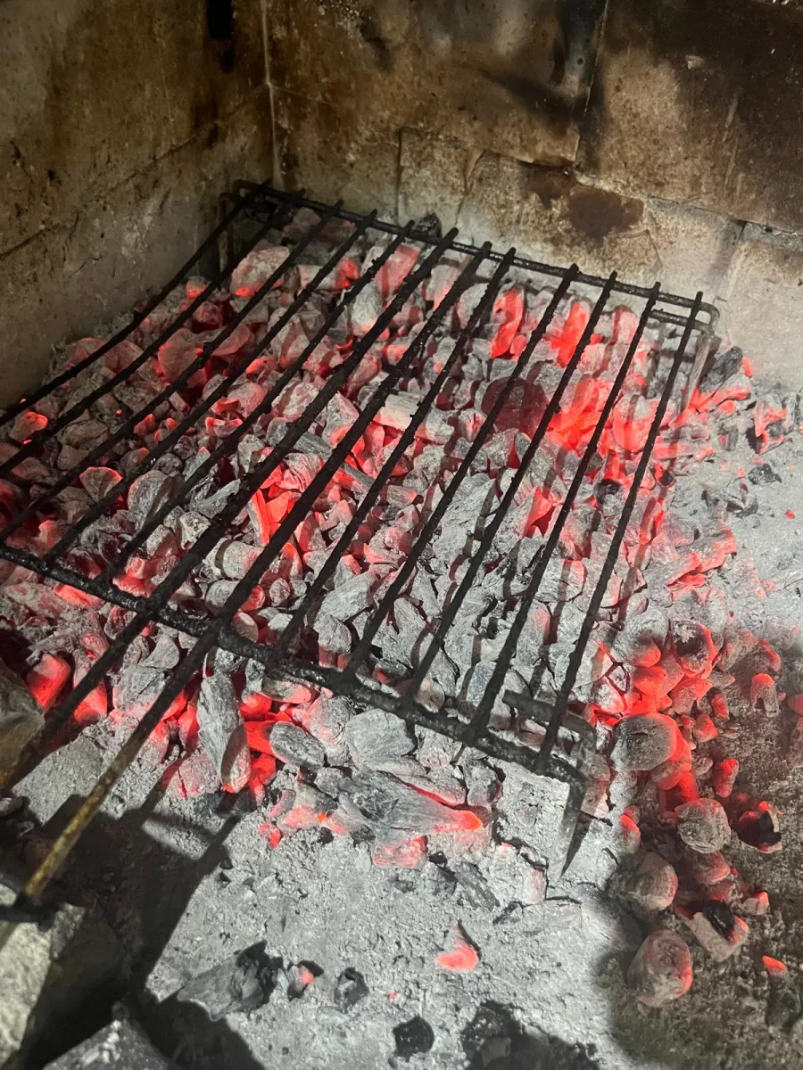 Carvão em brasa incandescente na grelha do restaurante Fogo e Tradição