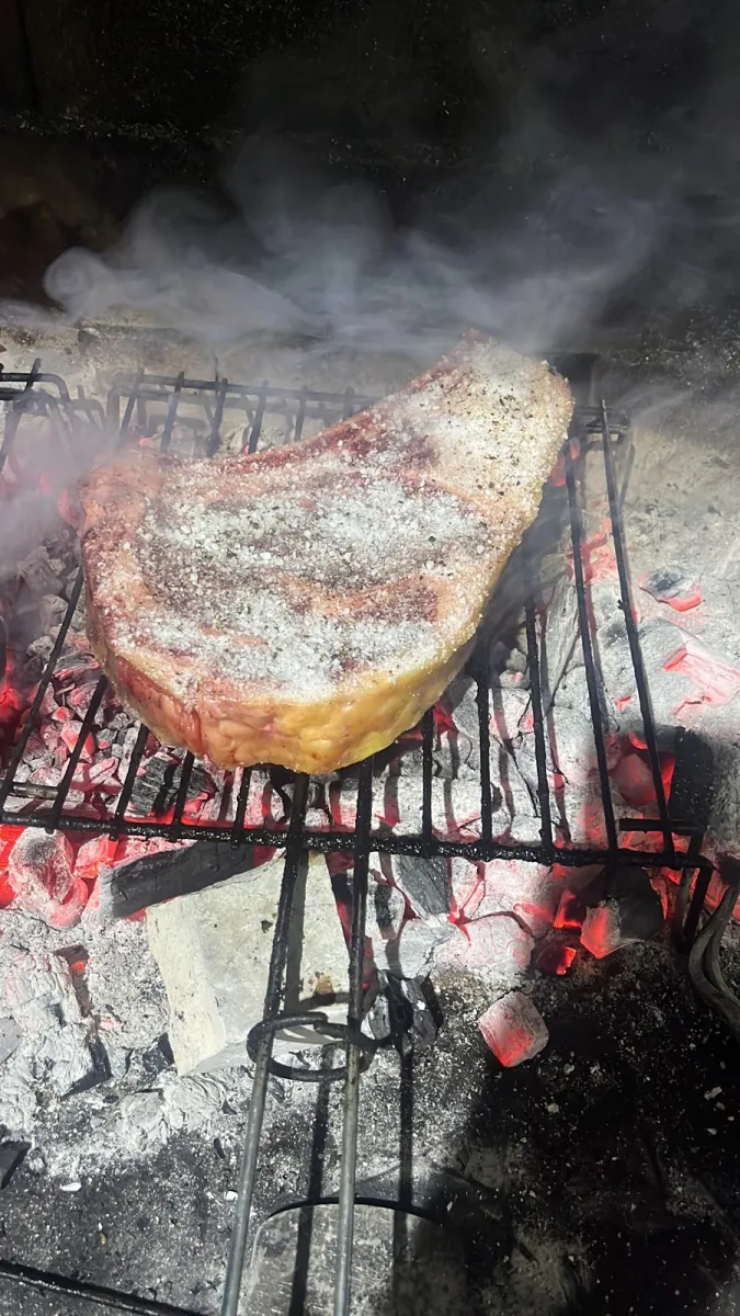 Costela fumada na grelha com brasas e fumo no Fogo e Tradição