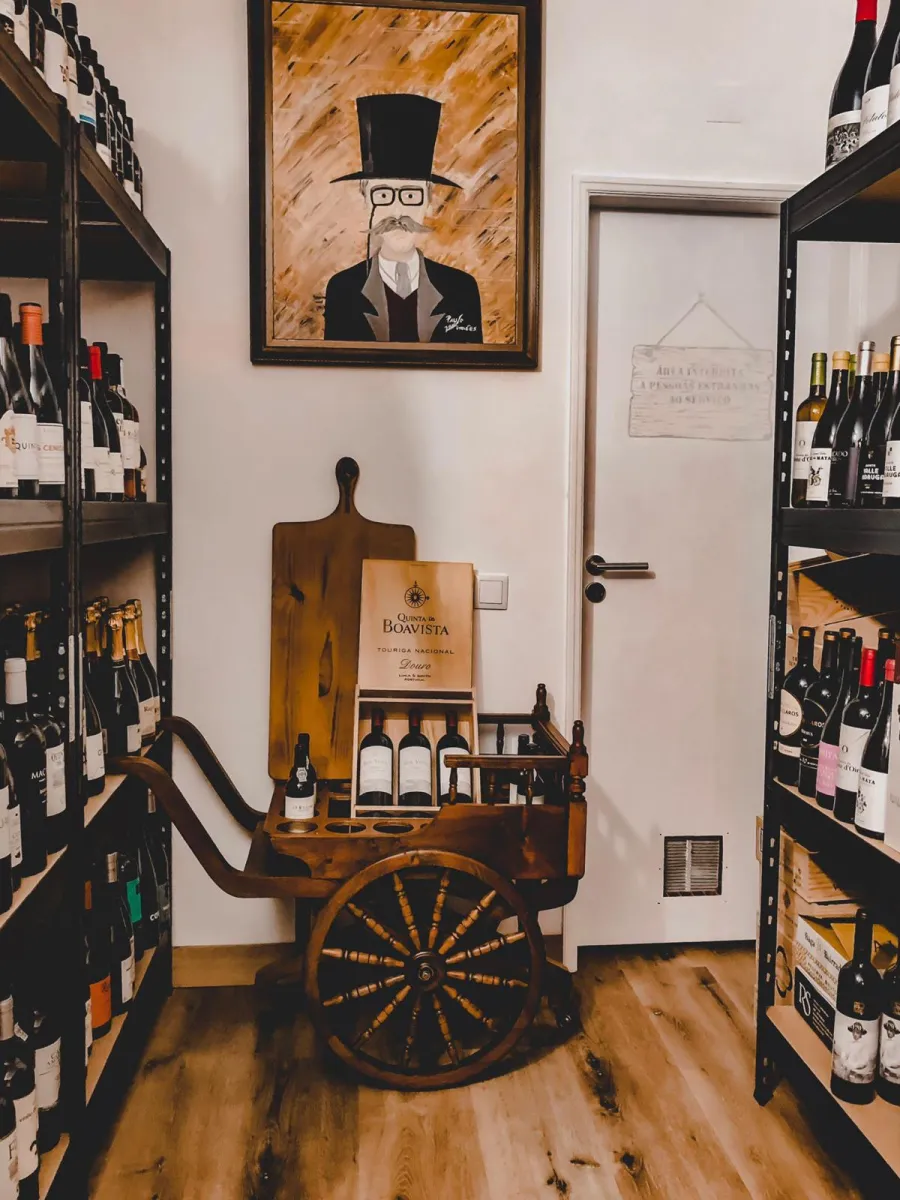 Garrafeira do Fogo e Tradição com carrinho de madeira e prateleiras de garrafas